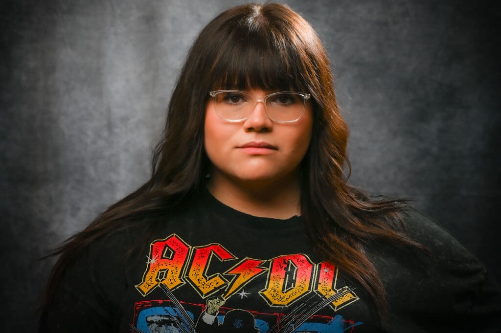 Portrait taken with studio light, young woman, dark brown hair and glasses.